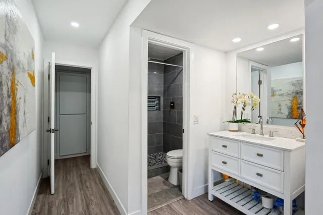 a bathroom with a sink a toilet and shower