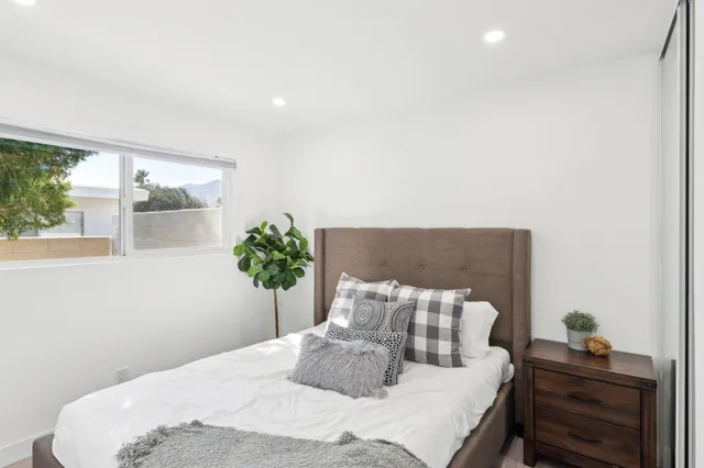 a bedroom with a bed and a potted plant
