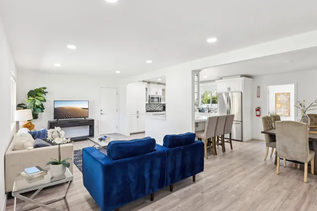 a living room with furniture a wooden floor and a flat screen tv