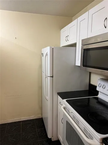 a kitchen with a refrigerator sink and cabinets