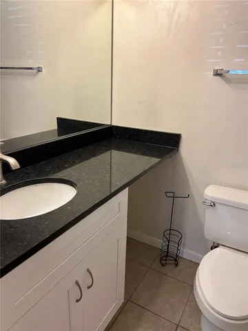 a blue bathroom with a granite countertop sink and a toilet