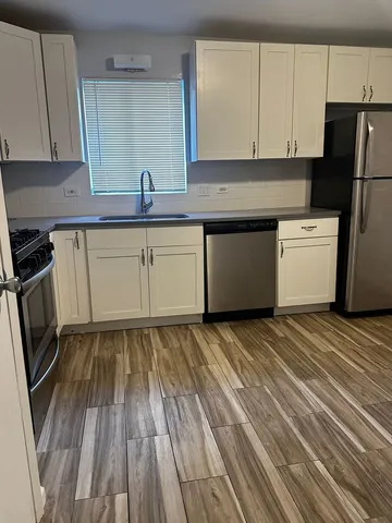 a kitchen with granite countertop white cabinets and white appliances