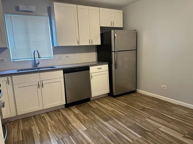 a kitchen with a sink a refrigerator and cabinets