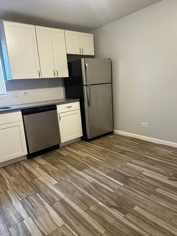a kitchen with a refrigerator and a stove top oven