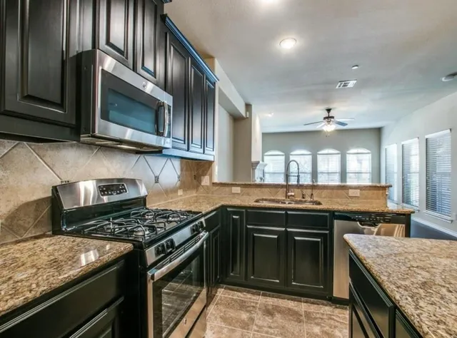 a kitchen with granite countertop stainless steel appliances and stove