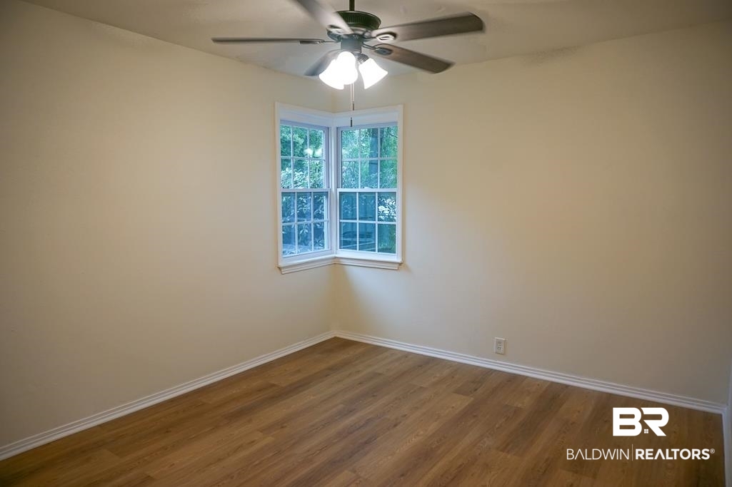 4734 Kirkwell Drive Mobile, AL 36619 - Photo 13 of 18 Empty room with ceiling fan and hardwood / wood-style floors