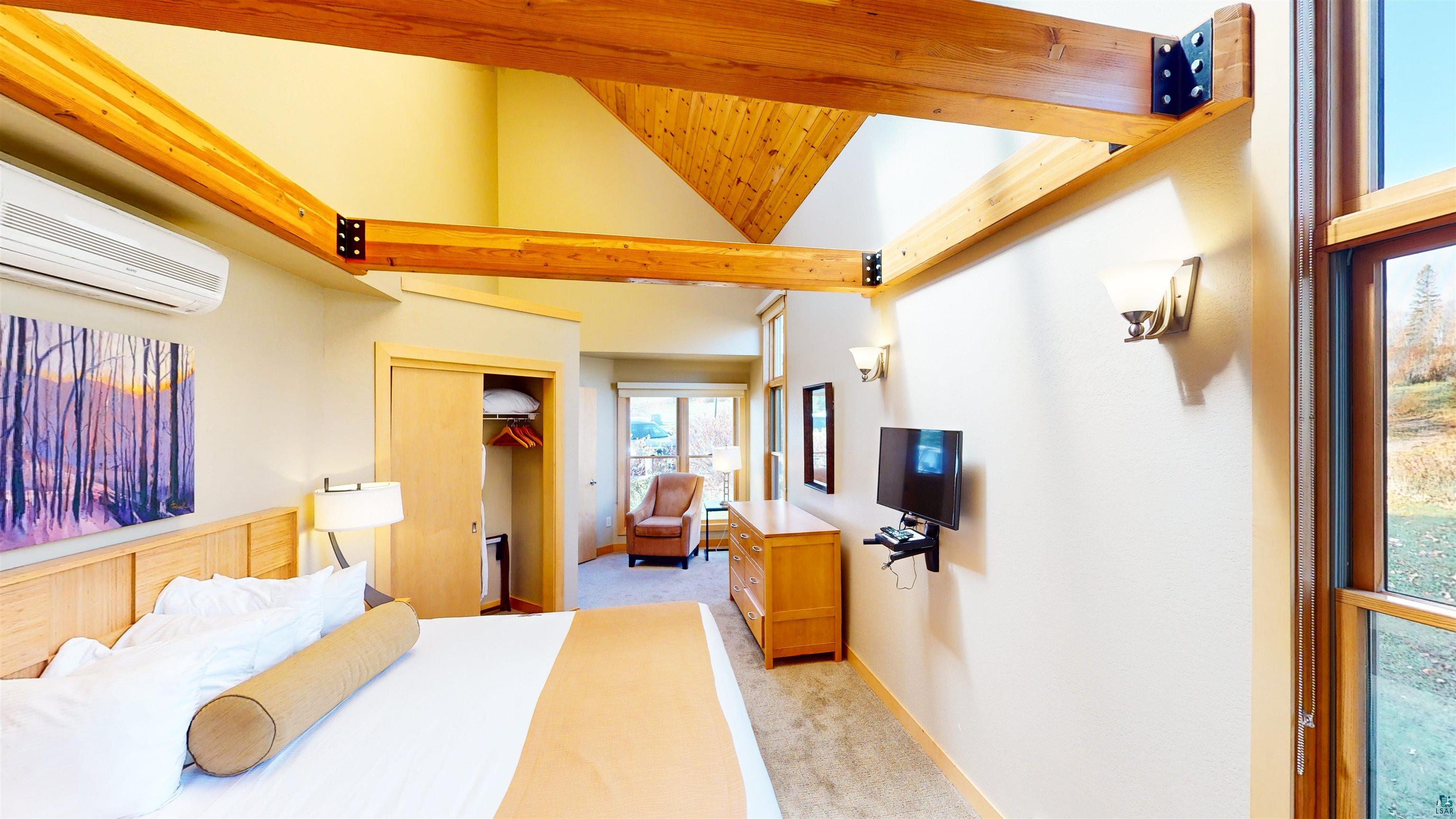 40 Surfside Drive, Unit 5D Tofte, MN 55615 - Photo 11 of 37 Vaulted ceilings featuring exposed wood beams and architectural ceiling lines