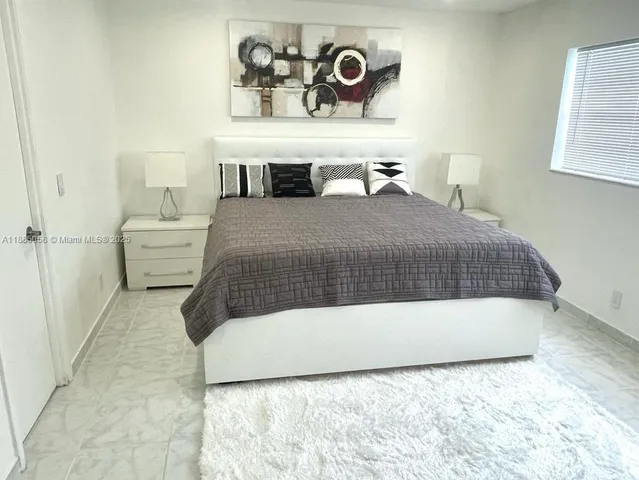 a bedroom with a bed and painting on the wall