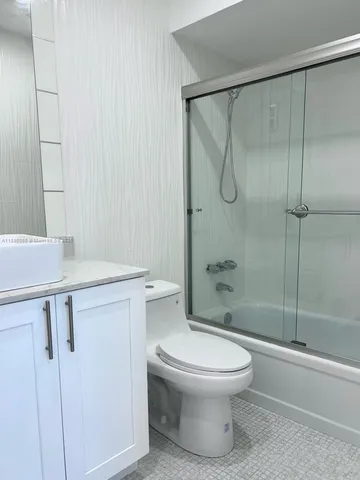 a bathroom with a shower toilet and sink