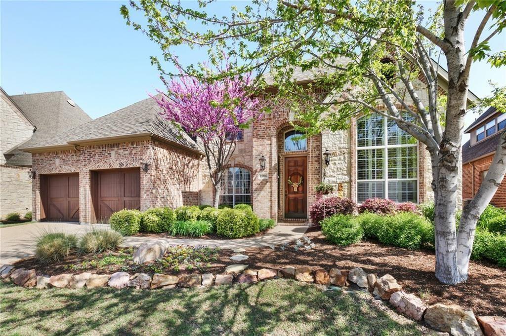 a front view of a house with garden and trees