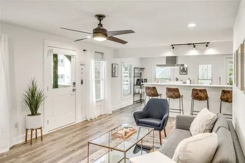 a living room with furniture and a wooden floor