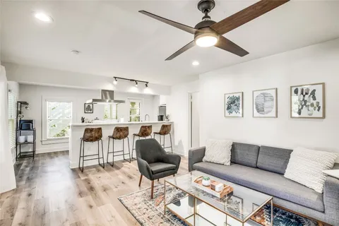 a living room with furniture and a wooden floor