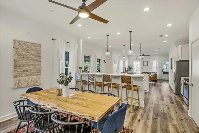 a very nice looking dining room with kitchen island a table and chairs