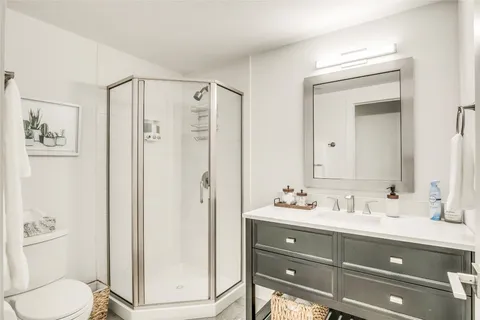 a bathroom with a sink a toilet and shower