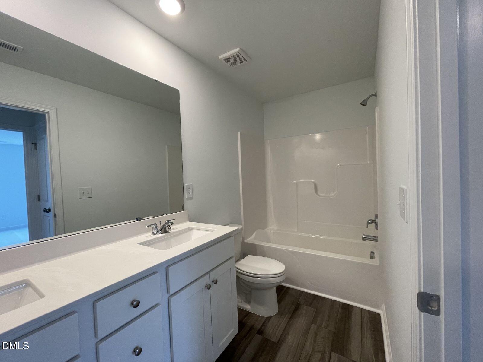 213 Lily Patch Lane Smithfield, NC 27577 - Photo 13 of 13 a bathroom with a sink a toilet a shower and a mirror