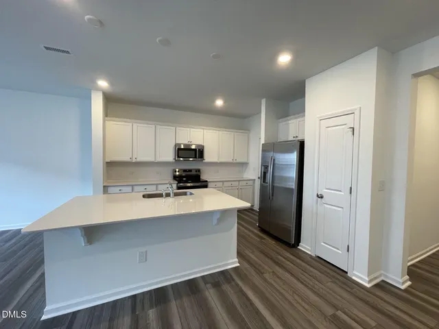 a large kitchen with stainless steel appliances a refrigerator and a stove