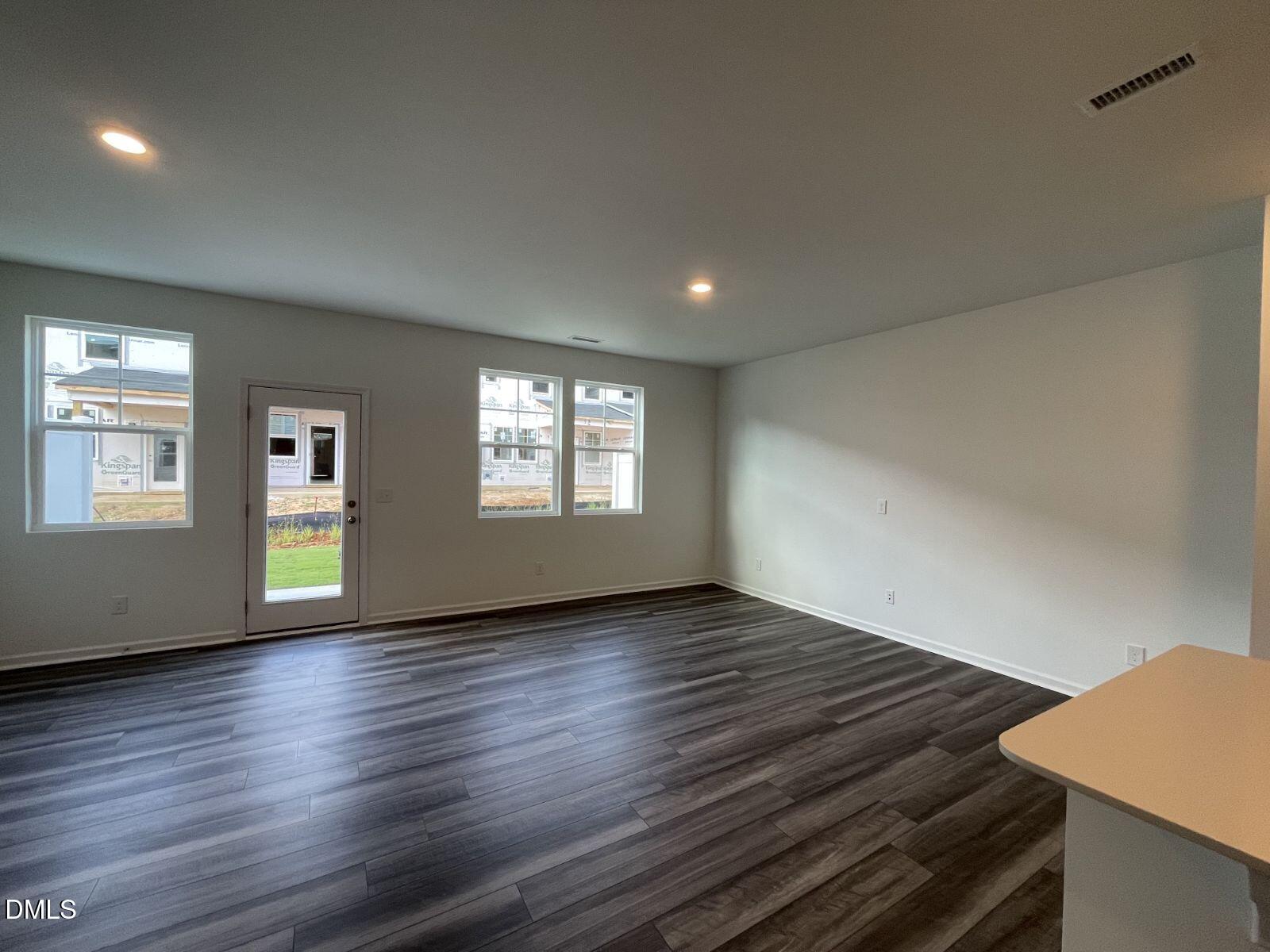 213 Lily Patch Lane Smithfield, NC 27577 - Photo 8 of 13 a view of an empty room with wooden floor and a window