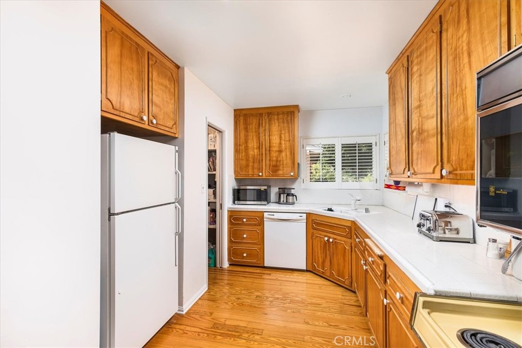 40057 South Shore Drive Fallbrook, CA 92028 - Photo 11 of 53 a kitchen with stainless steel appliances granite countertop a refrigerator a sink dishwasher a stove with wooden cabinets