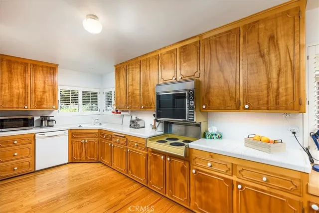 a kitchen with stainless steel appliances granite countertop a refrigerator a sink dishwasher a stove with wooden cabinets