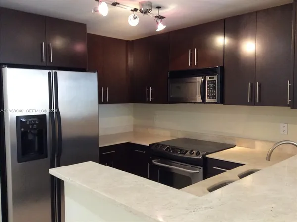 a kitchen with stainless steel appliances granite countertop a refrigerator a sink and a stove