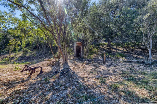 a view of a house with a yard tree and wooden fence