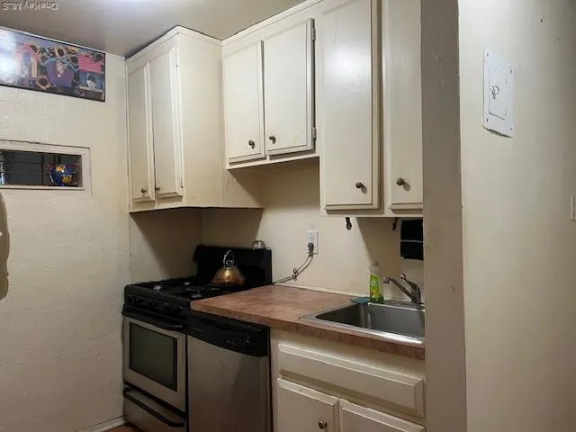 a kitchen with stainless steel appliances a refrigerator and a stove top oven