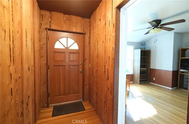 a view of a hallway with wooden floor and a bathroom