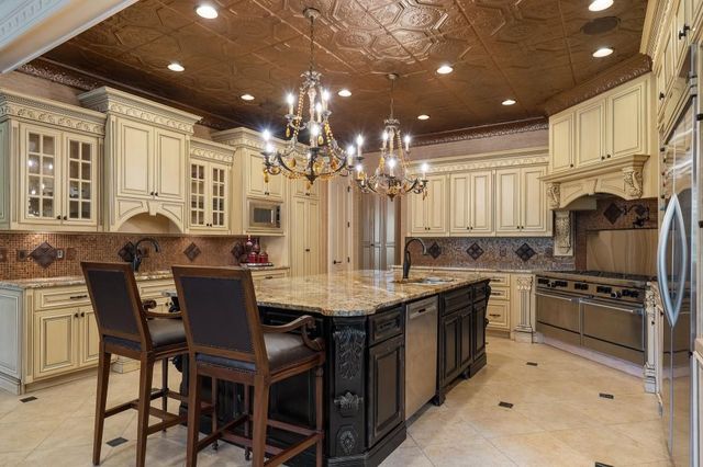 a kitchen with kitchen island granite countertop a table and chairs in it