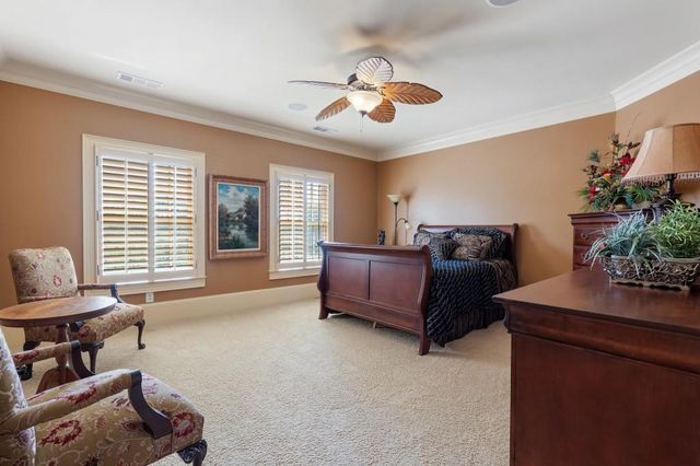 a spacious bedroom with a bed a couch and large windows
