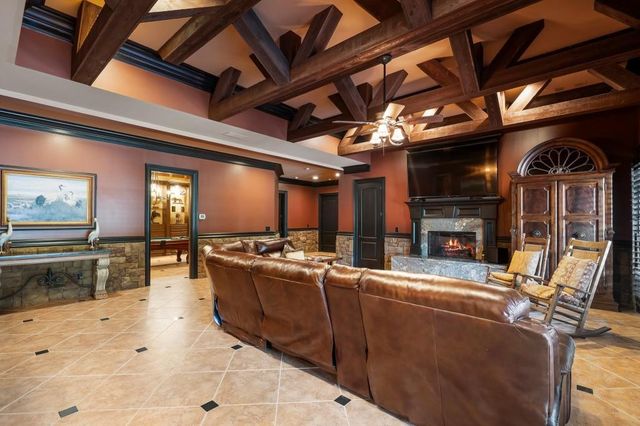 a living room with furniture pool table and stainless steel appliances