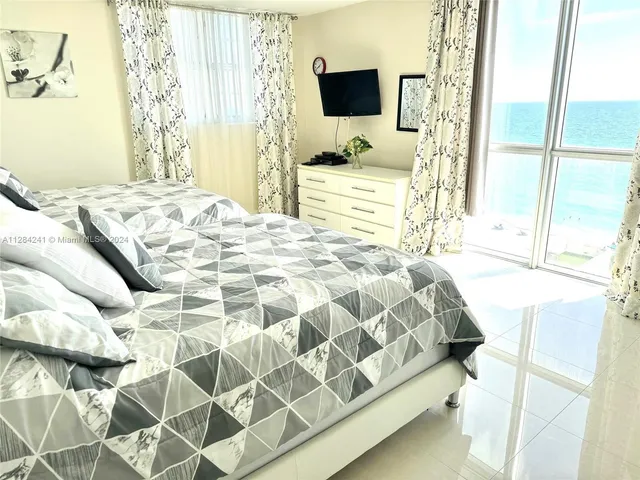 a bedroom with a bed tv and a window