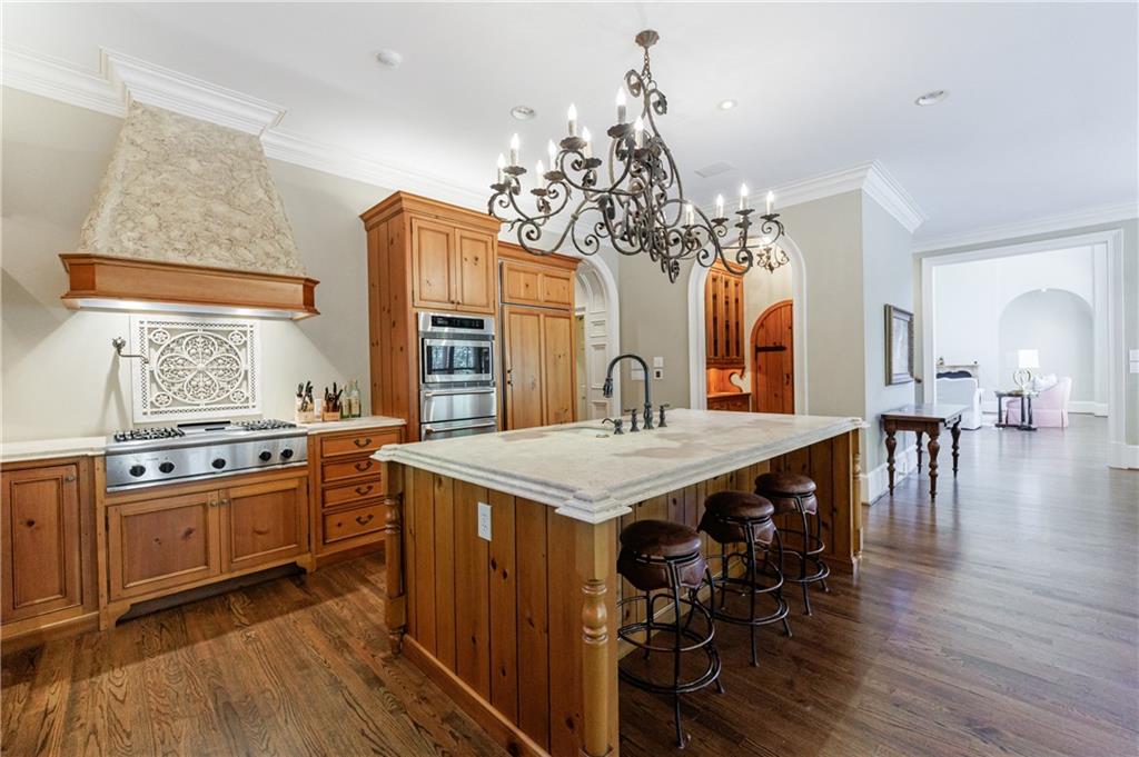 9390 Colonnade Trail Alpharetta, GA 30022 - Photo 21 of 122 a kitchen with stainless steel appliances granite countertop a stove top oven a sink dishwasher and white cabinets with wooden floor