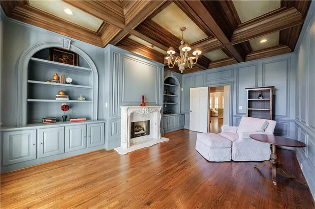 a kitchen with stainless steel appliances granite countertop a stove top oven a sink dishwasher and white cabinets with wooden floor