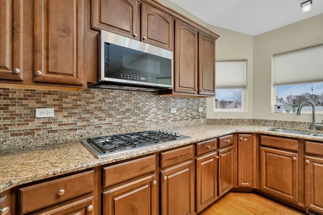 a kitchen with granite countertop stainless steel appliances a stove sink and microwave