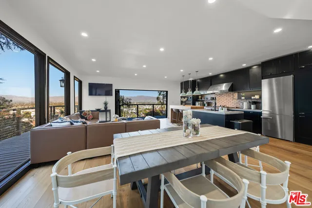 a living room with furniture a wooden floor and a flat screen tv