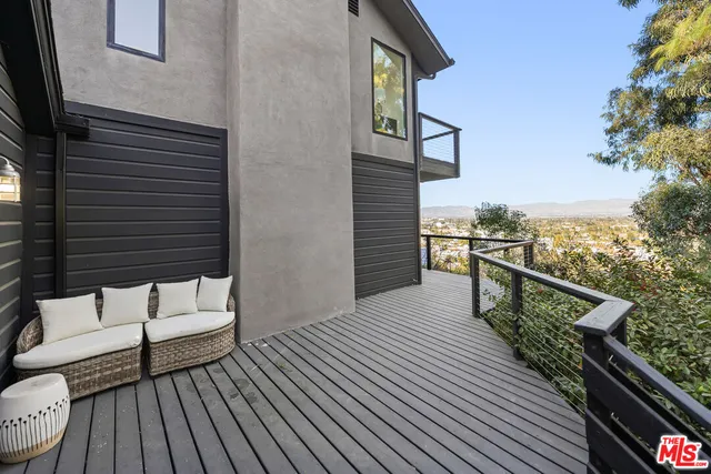 a view of a balcony with wooden floor & fence