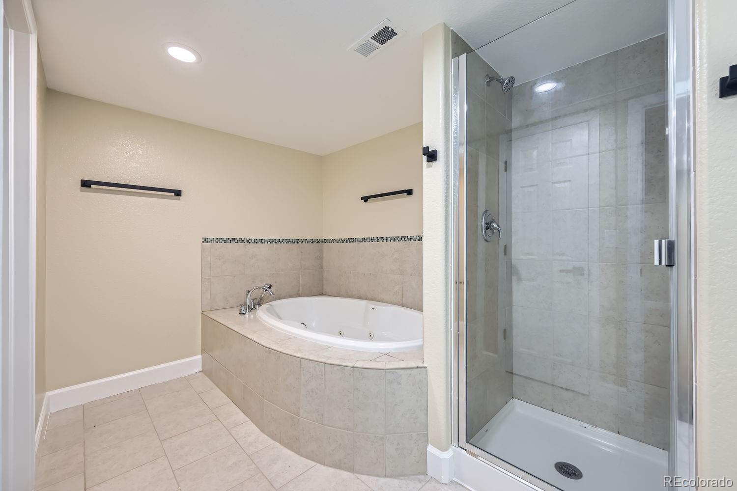 6596 Silverleaf Avenue Firestone, CO 80504 - Photo 23 of 26 a bathroom with a bathtub a shower a sink and mirror