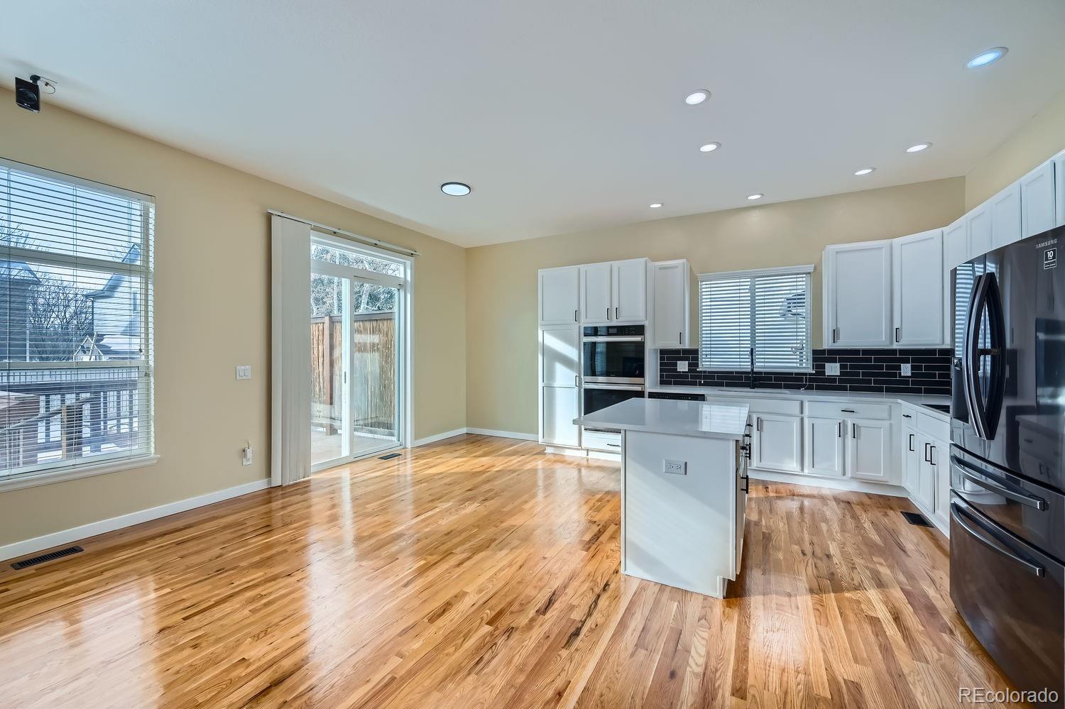 6596 Silverleaf Avenue Firestone, CO 80504 - Photo 9 of 26 a kitchen with wooden floors and refrigerator