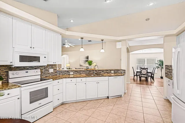 a kitchen with granite countertop cabinets a dining table and chairs