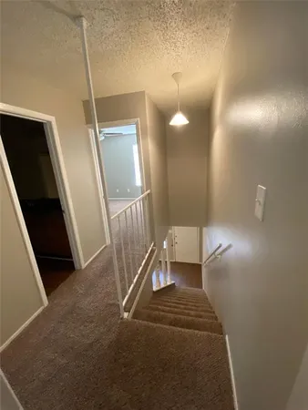 a view of staircase with white walls and railing