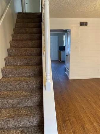 a view of a big room with wooden floor a ceiling fan and windows