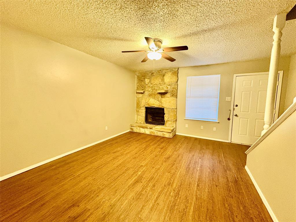 1407 Courtney Place, Unit B Cleburne, TX 76033 - Photo 15 of 16 a view of a big room with wooden floor a ceiling fan and windows