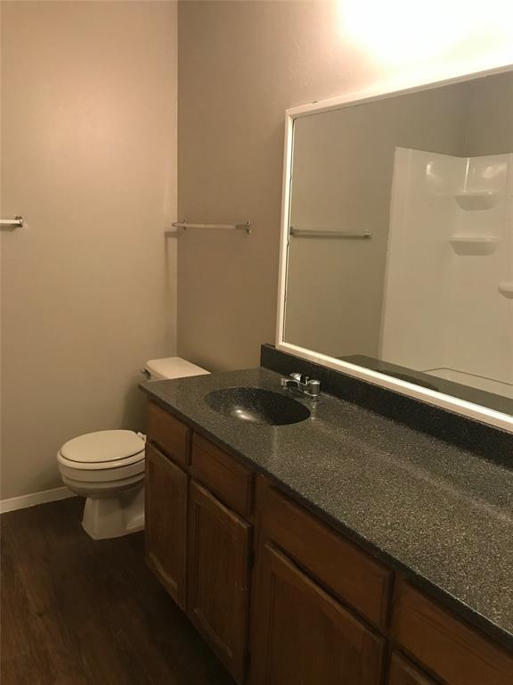 1407 Courtney Place, Unit B Cleburne, TX 76033 - Photo 9 of 16 a bathroom with a granite countertop sink and a toilet