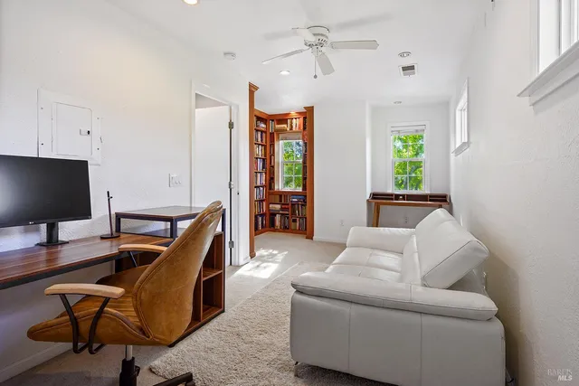 a view of a livingroom with workspace and a window