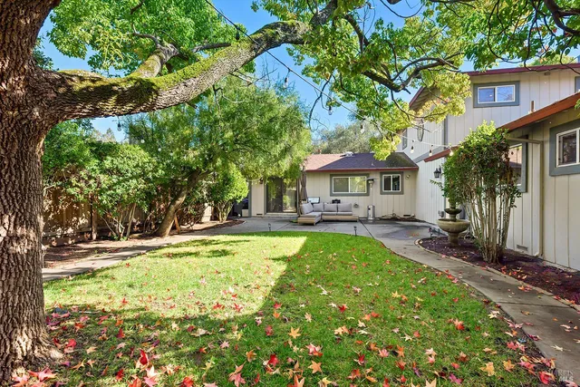 a view of a house with backyard and sitting area