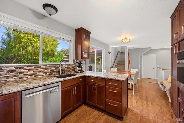 a kitchen with a stove a sink and a wooden floor