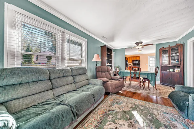 a living room with furniture a flat screen tv and a floor to ceiling window