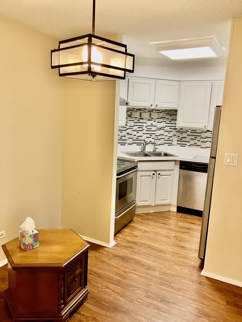 9514 Lawrence Avenue, Unit 2204 Schiller Park, IL 60176 - Photo 3 of 8 a kitchen with stainless steel appliances granite countertop a stove a sink and a refrigerator