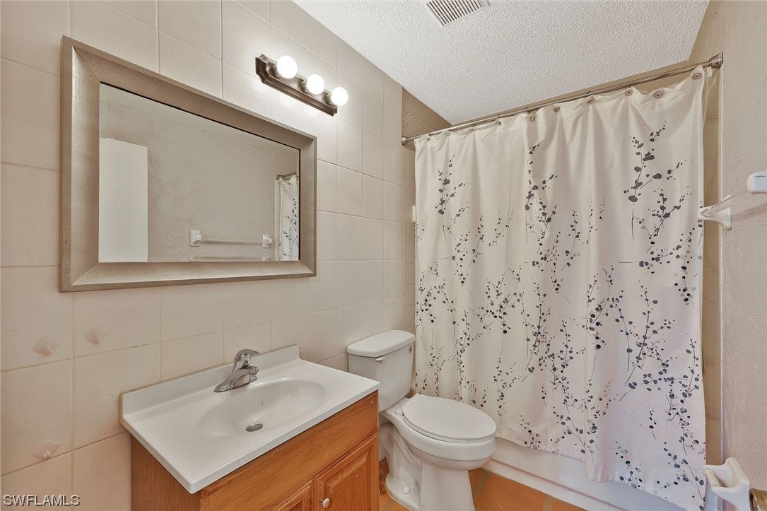 13373 Broadhurst Loop Fort Myers, FL 33919 - Photo 17 of 25 a bathroom with a sink a toilet and shower curtain