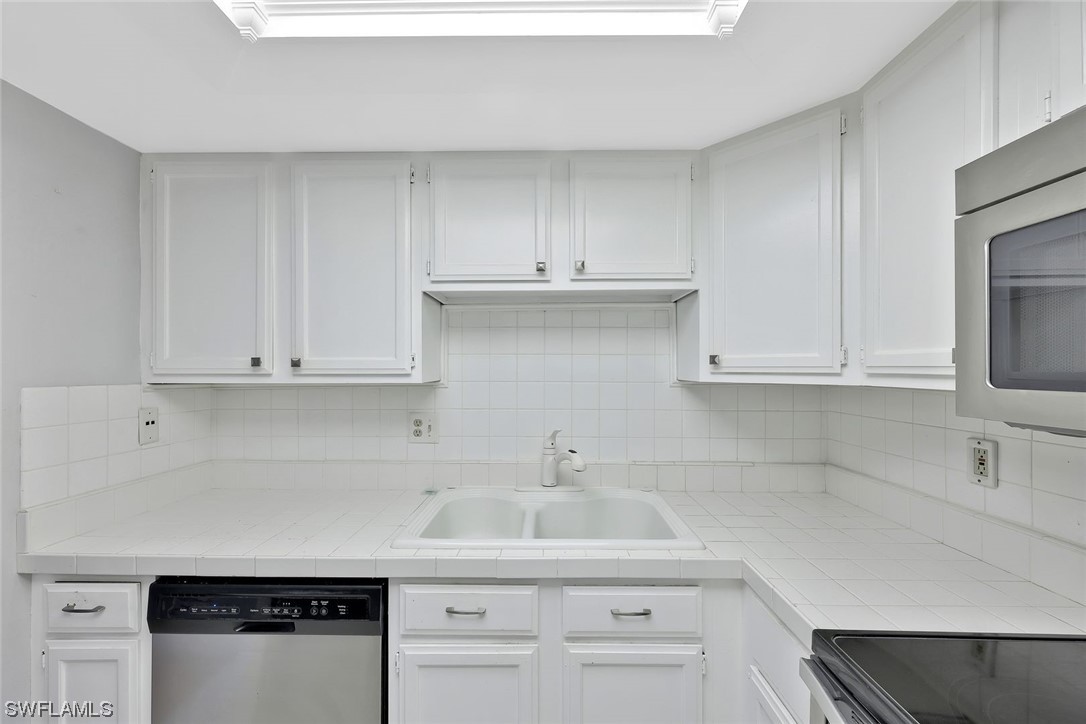 13373 Broadhurst Loop Fort Myers, FL 33919 - Photo 6 of 25 a kitchen with white cabinets and a sink